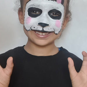 Final step, Outlining the face with black ‘zigzag’ lines using a medium brush, then sponging on small pink circles for the cheeks to complete Panda face paint.