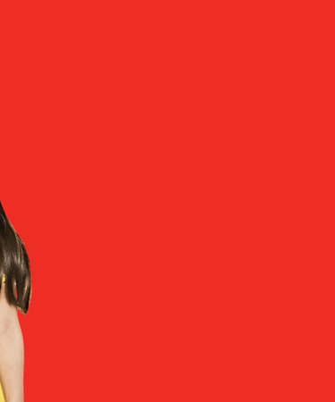 Four children with red face paint designs against a red background