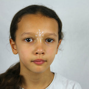 Step 1, paint a white snowflake between the eyebrows to start your Christmas Sparkle Swirl